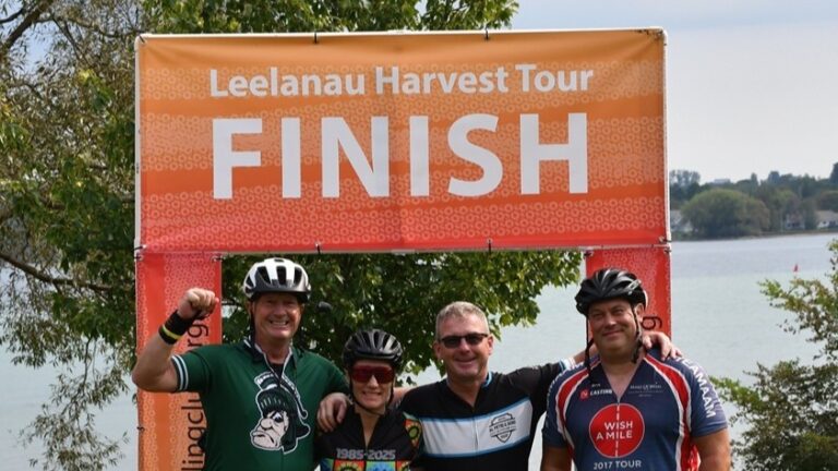 Four cyclists celebrating at the finish of the Leelanau Harvest Tour bike ride