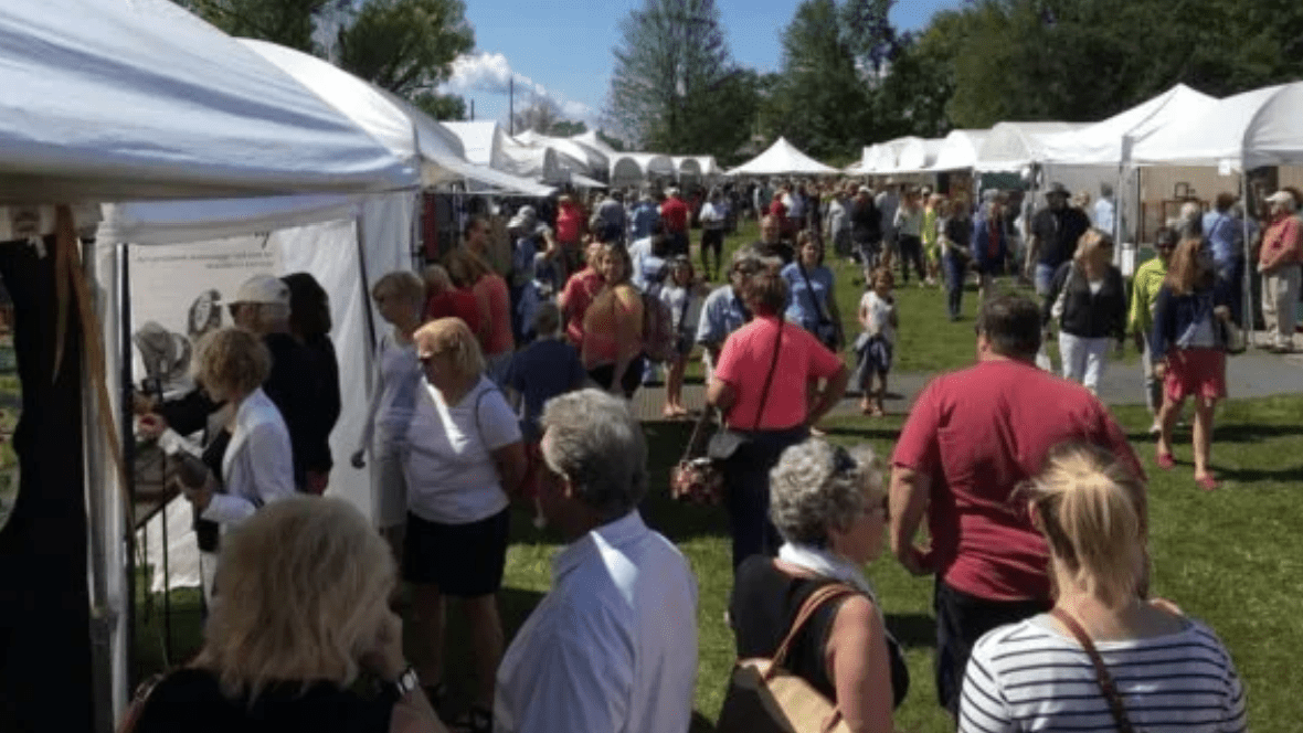 Photo of attendees walking between booths at the Suttons Bay Art Festival