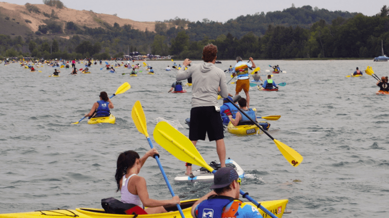 Kayak and SUP paddlers crossing Little Glen Lake during the final leg of the M22 Challenge